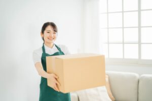 ダンボールを運ぶ女性